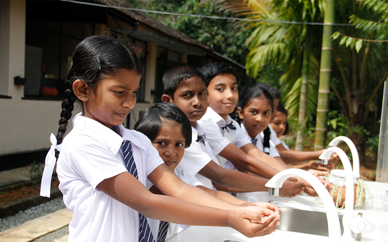 Children wash their hands at an outdoor sink
